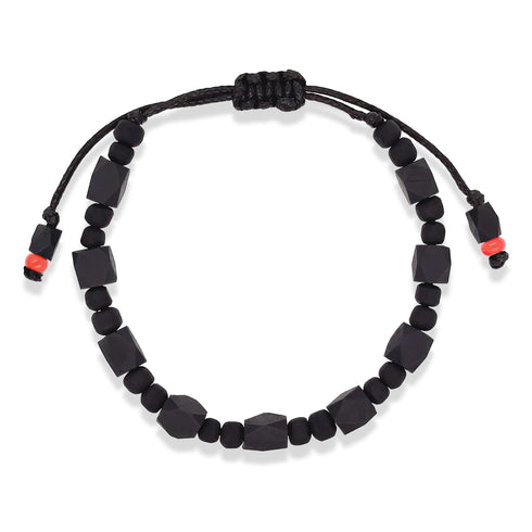 The Genuine Azabache Bracelet, designed as unisex jewelry for both men and women, offers spiritual protection with its geometric black beads and two small red accents. It features an adjustable black rope for easy fastening.