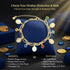 A 14k Gold-filled bracelet with coin and Evil Eye charms rests on a blue cushion, gold coins scattered in the background.