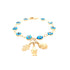 A gold bracelet featuring aqua blue evil eye beads is embellished with three exquisite charms: a Hamsa hand, a Virgin Mary figure, and an oval disk. It is beautifully arranged in a circle against a white background.