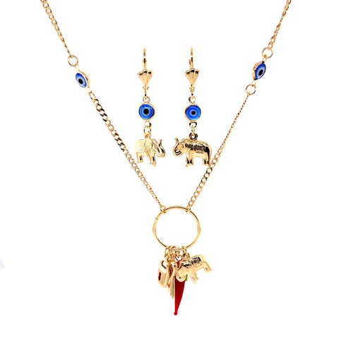The Mega Lucky Charm Pendant Necklace features a 14K gold-filled Cuban link chain adorned with charms like an elephant and a red horn, accompanied by matching earrings embellished with blue and gold accents and elephant charms. This set exudes elegance while providing a sense of protection and luck, all beautifully displayed against a white background.