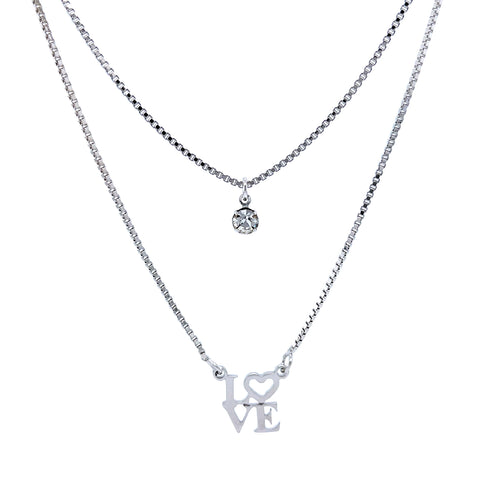 Two delicate silver necklaces on a white background. The top features a small round crystal pendant, while the bottom displays the Platinum Filled Love Pendant Stacked Necklace, showcasing a platinum-filled "LOVE" pendant with the heart replacing "O." Both are lead and nickel-free for safe and stylish wear.