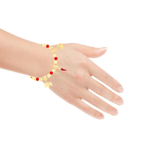 A hand wearing the Lovely Elephant, Clover and Chili Lucky Charm Bracelet, crafted with 14k Gold Filled material and adorned with red beads and gold charms in the shapes of animals and letters for spiritual protection, is beautifully displayed against a white background.