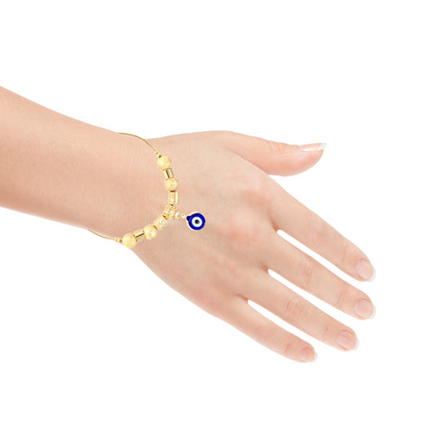 A hand adorned with the Blue Evil Eye Charm Bracelet, featuring a 14k gold-filled snake chain link design and small round beads surrounding a central blue evil eye charm. The minimalistic elegance is beautifully highlighted against the plain white background.