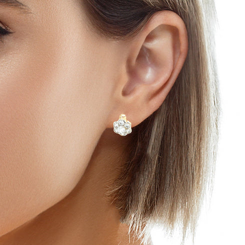 Close-up of a woman's ear adorned with Daisy flower Zirconia stone Huggie Earrings in rose gold-filled, shimmering beautifully. Her short, straight hair is partially visible, and her light skin tone enhances the sparkle against the softly blurred background.